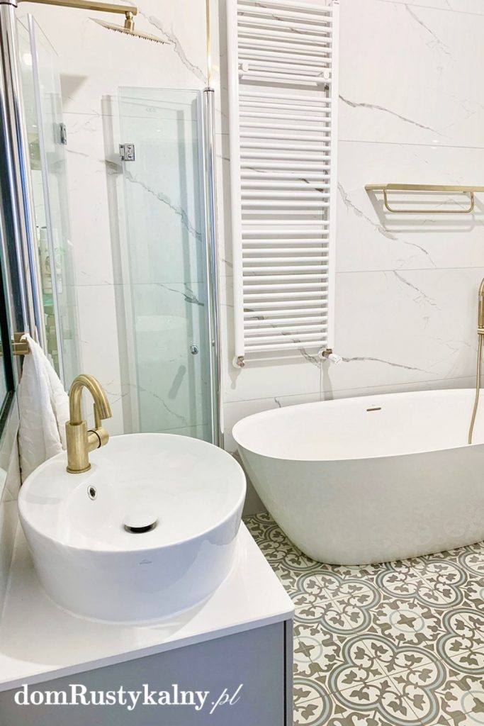 Biała łazienka z wanna i prysznicem, na podłodze płytki cementowe z ornamentem