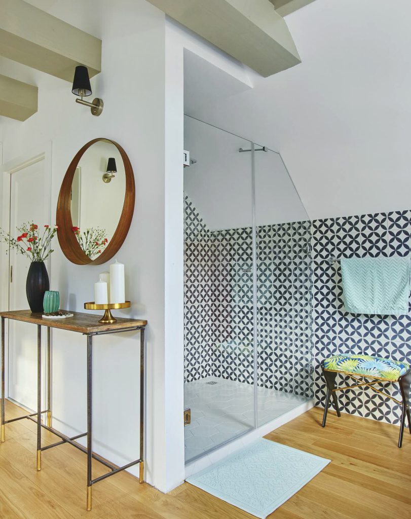 Łazienka na poddaszu, biało czarne kafle marokańskie na ścianie prysznica, drewniana podłoga.