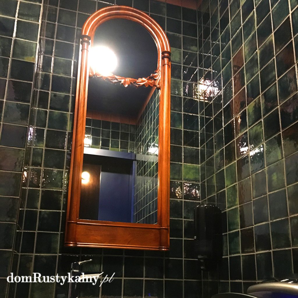 Ciemna, designerska łazienka w błyszczącej zielonej glazurze artisan z drewnianym lustrem – mała łazienka w ciemnych kolorach 